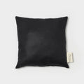 Coussin carré noir texturé avec étiquette sur le côté
