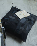 Coussin noir en patchwork géométrique, faces matelassées, forme rectangulaire
