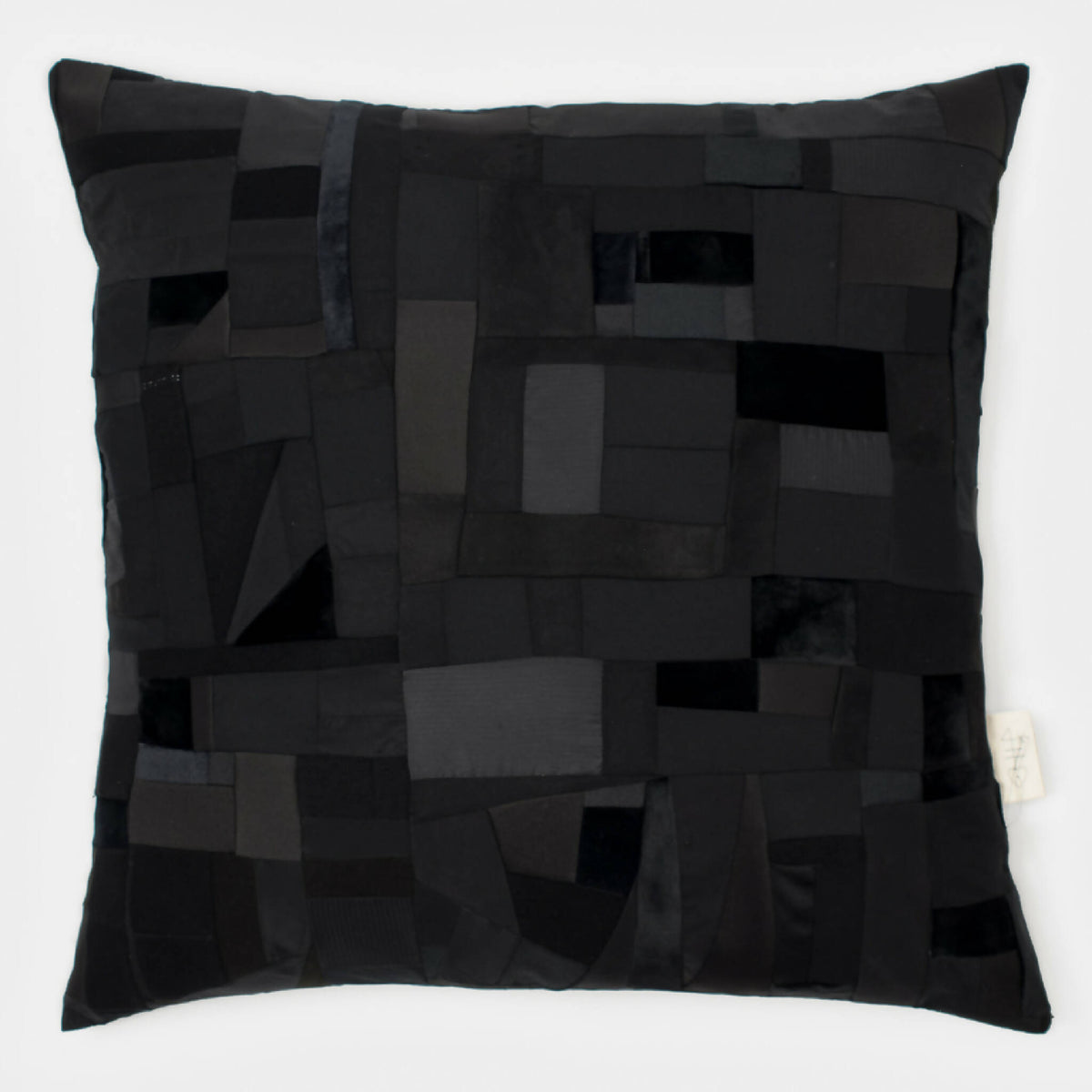 Coussin rectangulaire noir en patchwork de carrés et losanges, aspect matelassé
