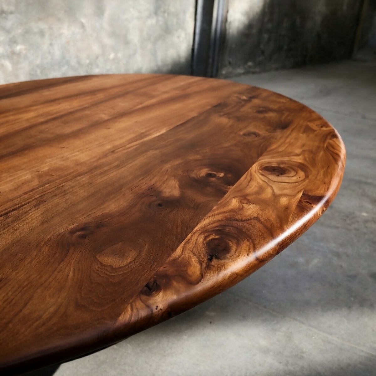 Plateau rond en bois avec veinage marqué, bord fin et surface lustrée