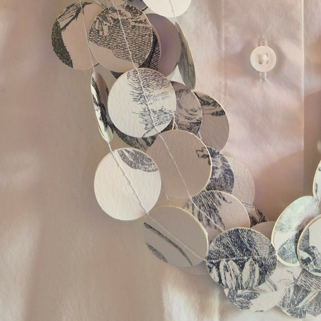Collier en disques ronds noir et blanc à motifs, gros plan sur l’assemblage