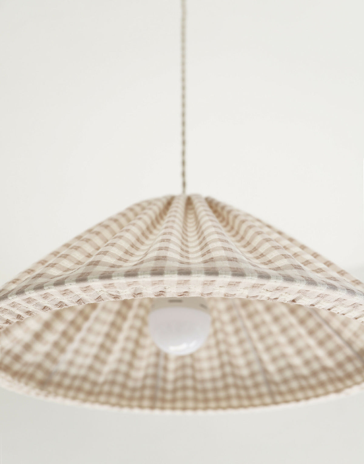 Suspension conique vichy beige clair, petits carreaux, gros plan du diffuseur blanc.