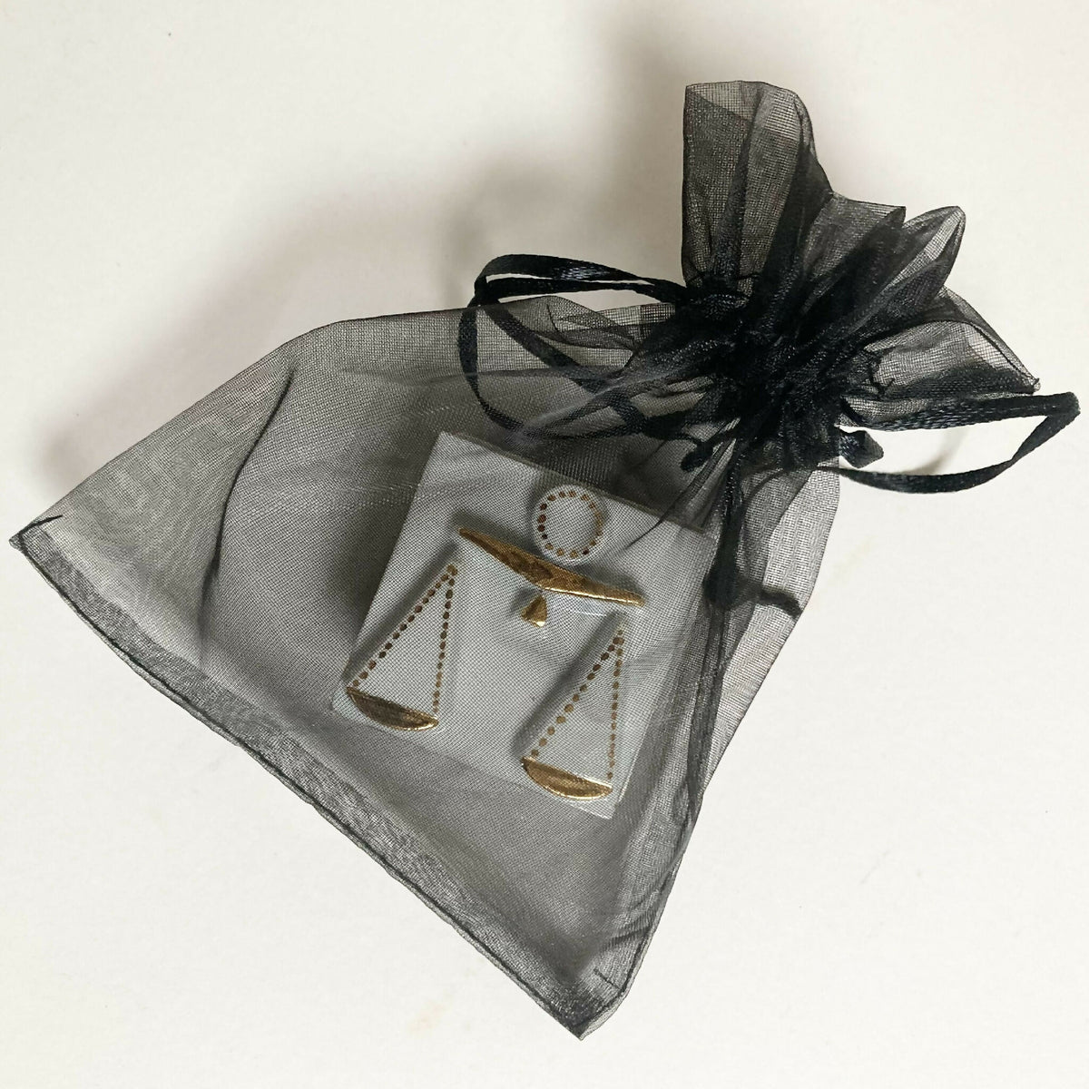 Boîte à bijoux en porcelaine blanche avec ruban organza noir, décor balances dorées.