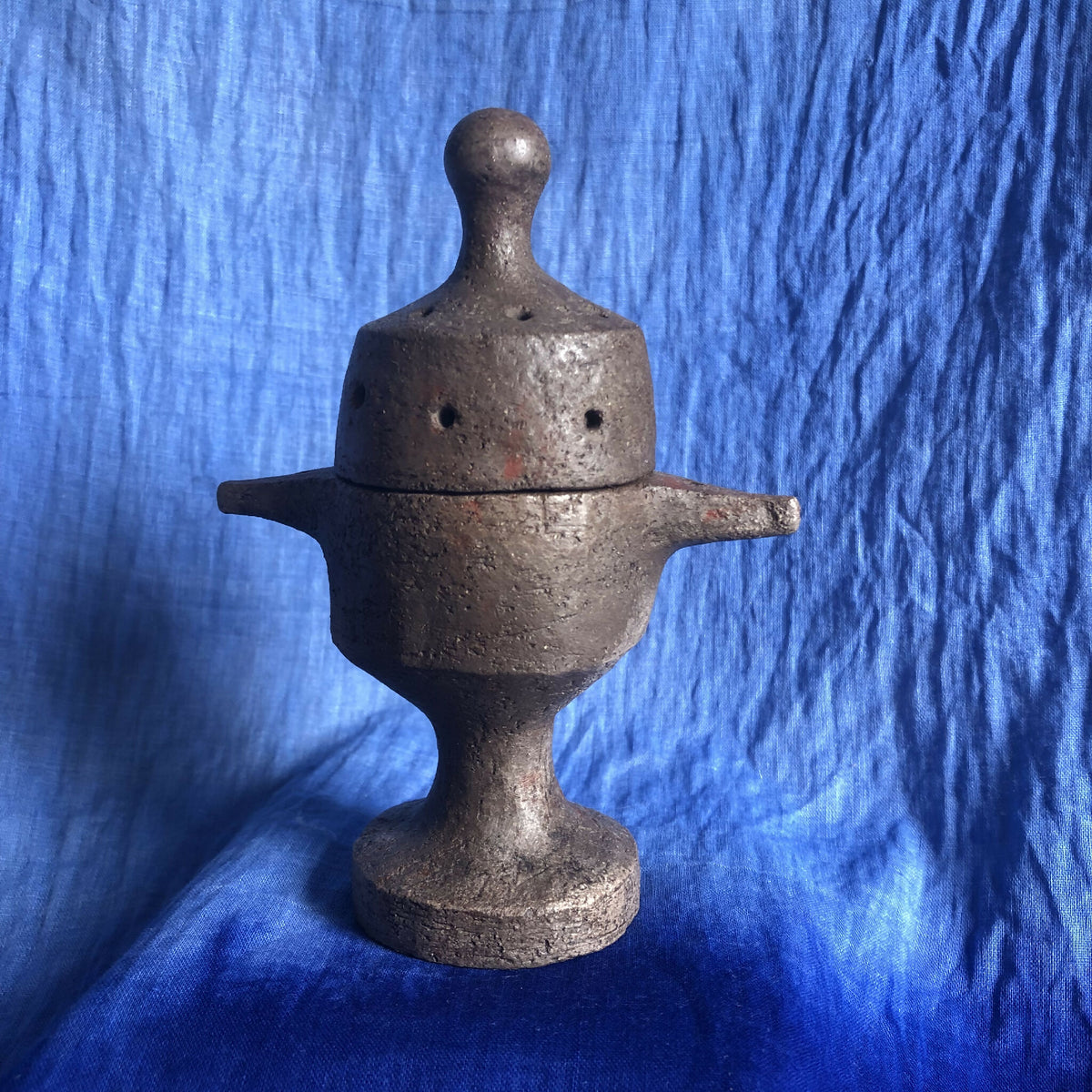 Encensoir en métal foncé avec couvercle perforé et large bec