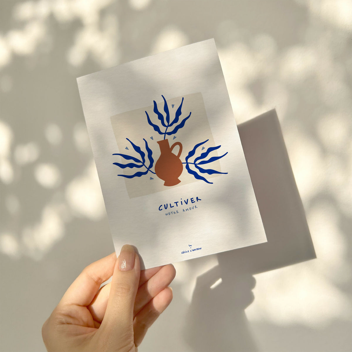 Carte de vœux blanche tenue en main, illustration bleu et terracotta « Cultiver »
