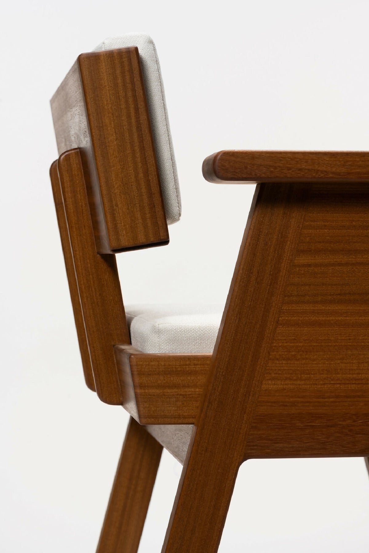 Fauteuil en bois clair avec accoudoir et dossier rembourrés blancs, vue latérale