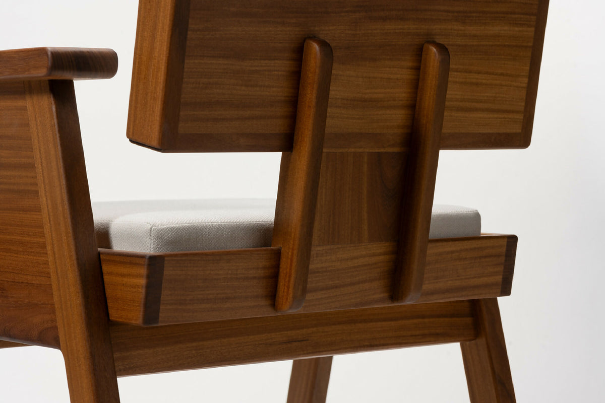 Fauteuil en bois clair, accoudoirs encastrés et dossier rembourré blanc, détail avant
