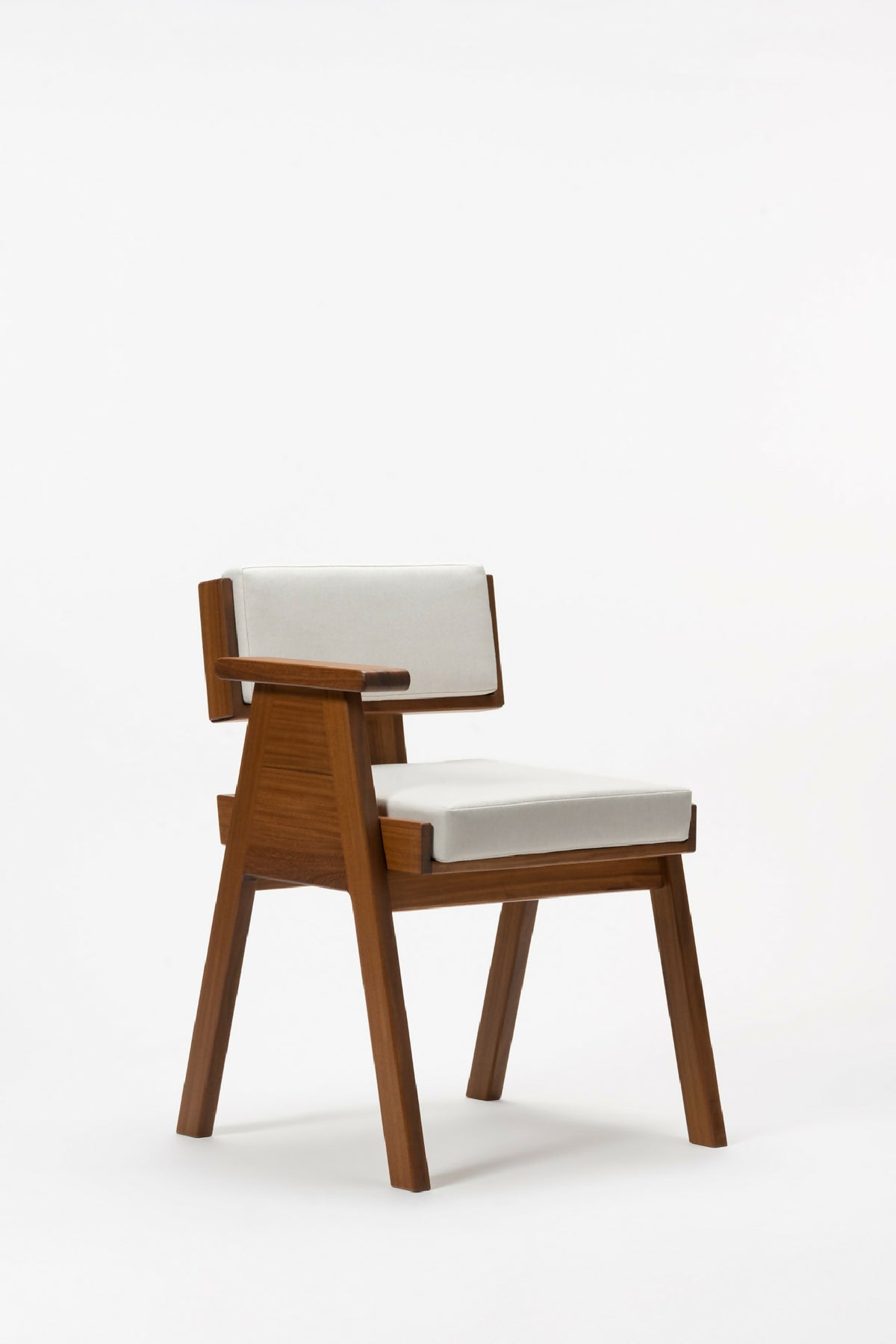 Fauteuil en bois clair, assise blanche et dossier rectangulaire rembourré, vue trois-quarts