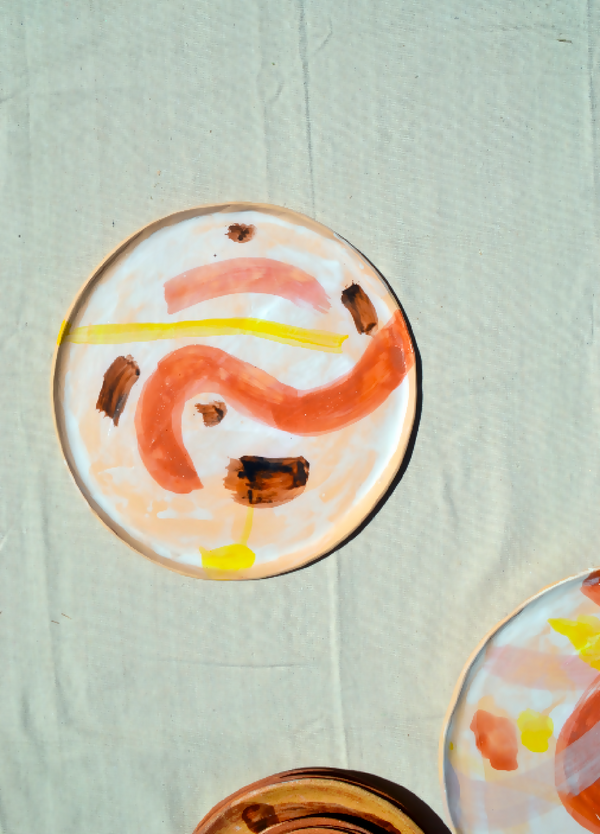Plateau circulaire motif abstrait orange, rose et brun sur fond clair