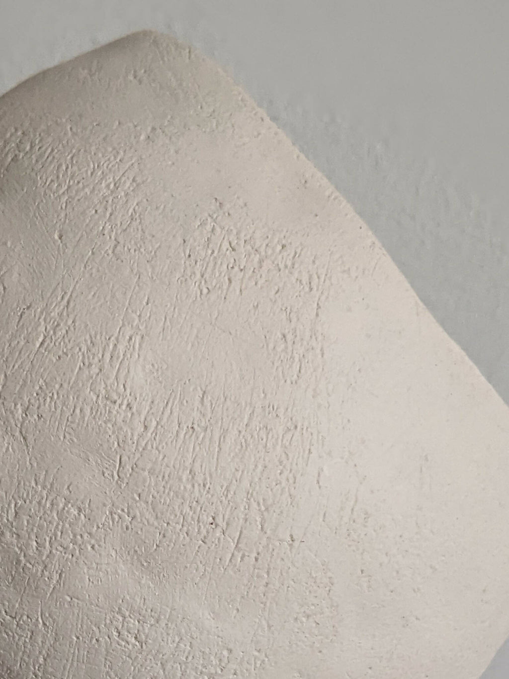 Lampe années 60 en céramique blanc cassé, gros plan sur la texture et la forme