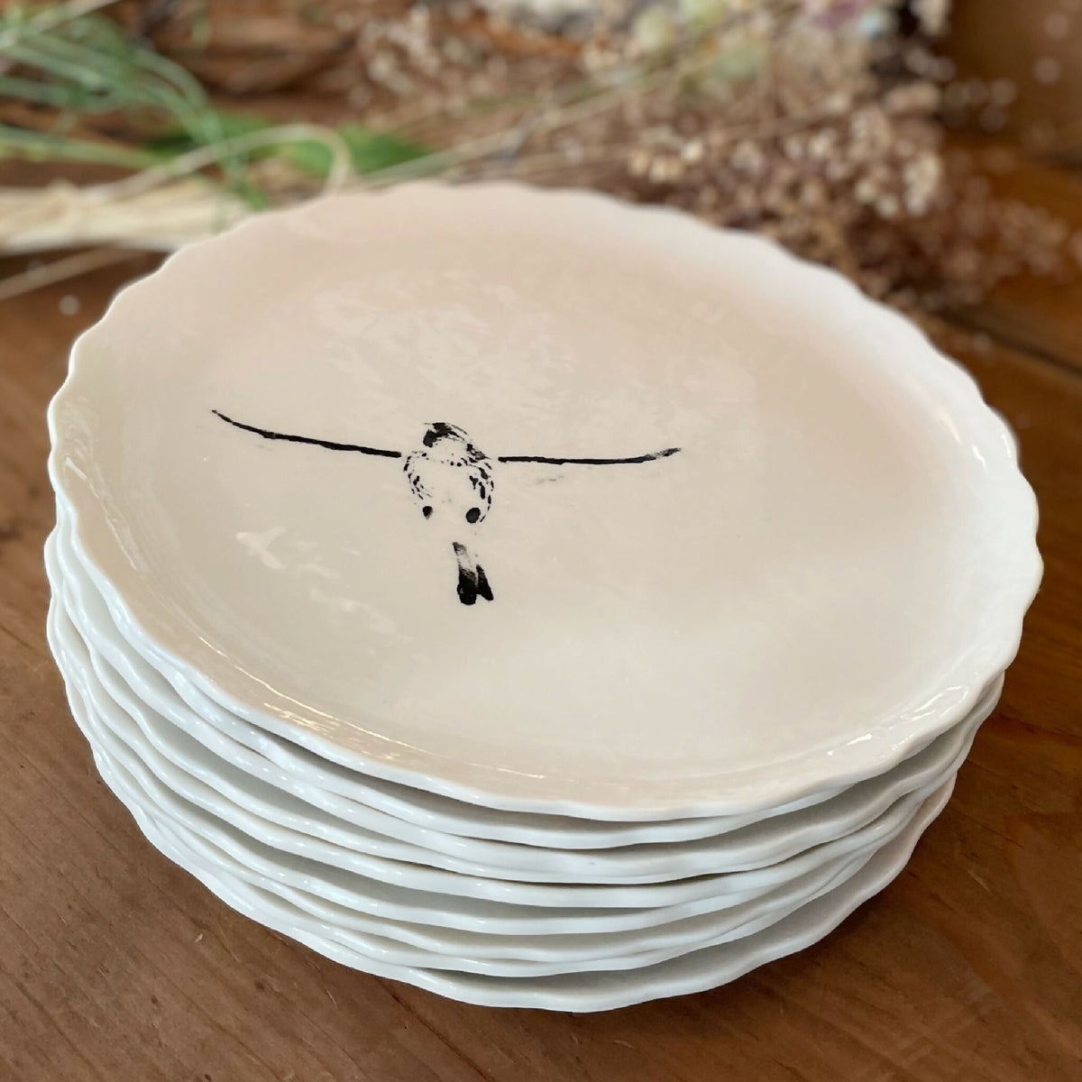Assiette à dessert en porcelaine blanche, bord festonné, oiseau noir peint au centre