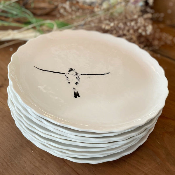 Assiette à dessert en porcelaine blanche, bord festonné, oiseau noir peint au centre