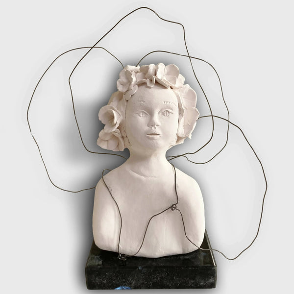 Buste de sculpture en pierre claire, couronne de fleurs, socle noir.