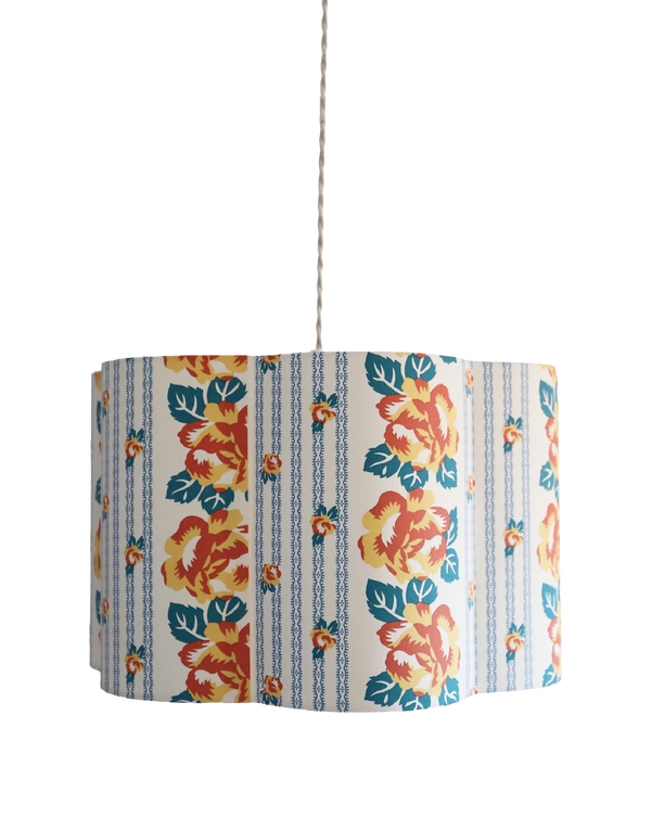 Abat-jour forme fleur en tissu bleu clair, fleurs orange et rayures de chaînettes.