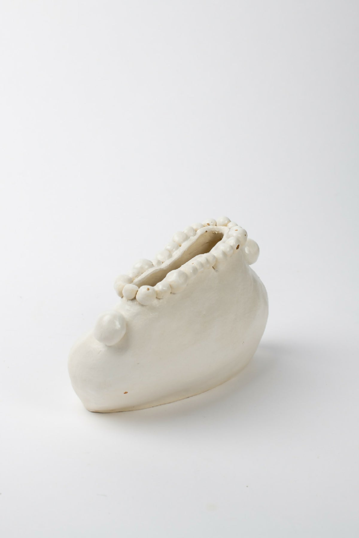 Vase en céramique blanche avec anses latérales et bord orné de petites perles