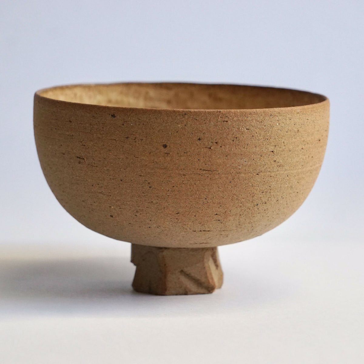 Bol en grès beige, forme évasée avec petit pied, vue de côté.