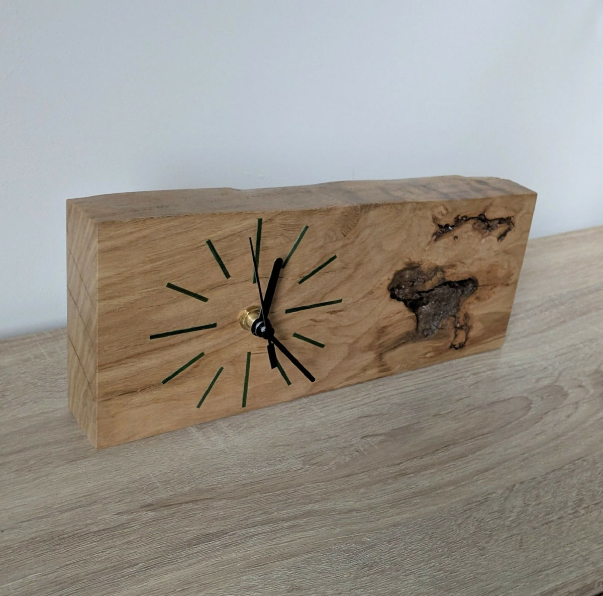 Horloge de bureau en bois clair avec aiguilles noires, repères verts et nœud décoratif.