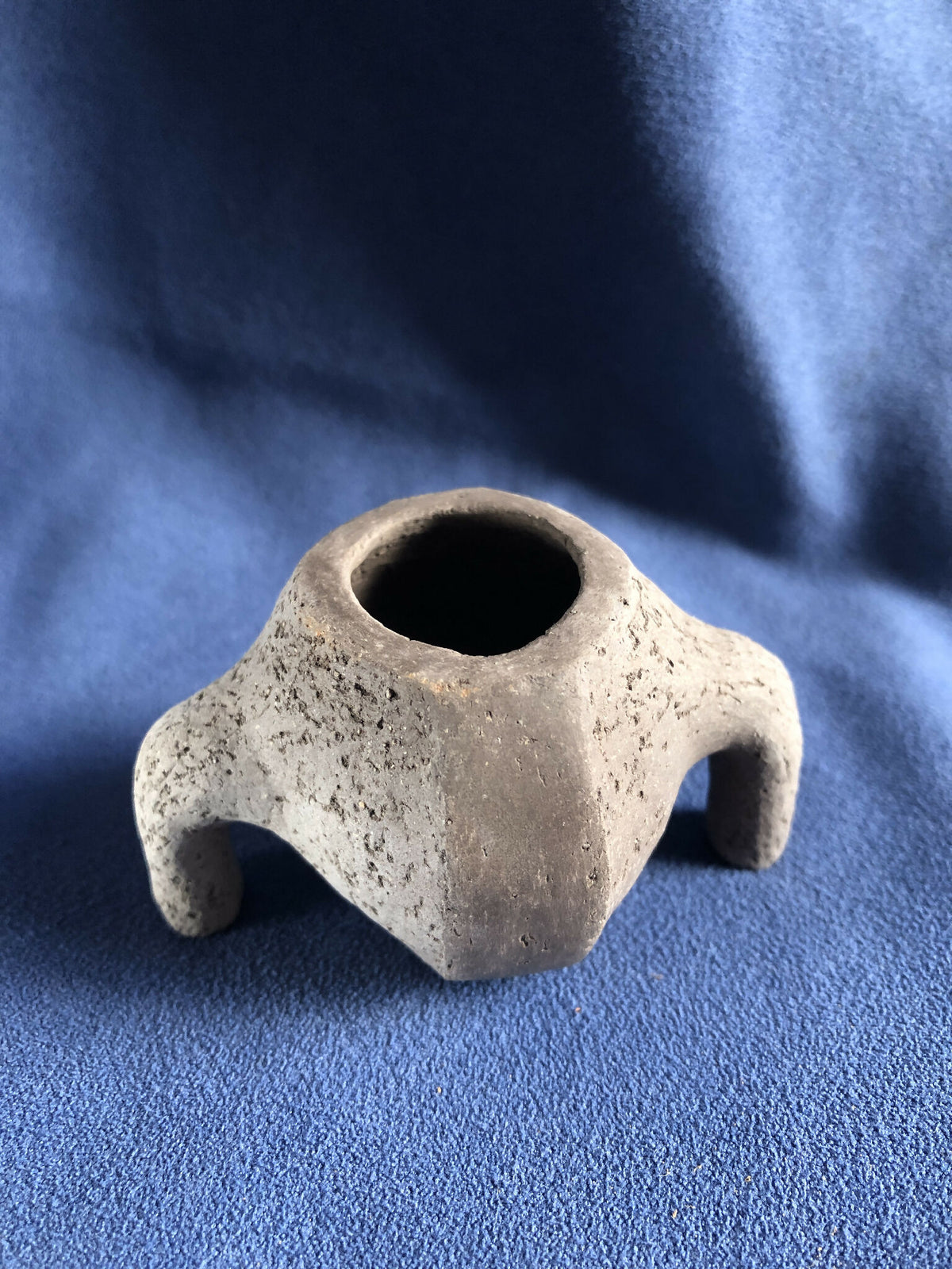 Petit pot en pierre texturée gris clair, ouverture ronde, deux petites pattes de chaque côté.