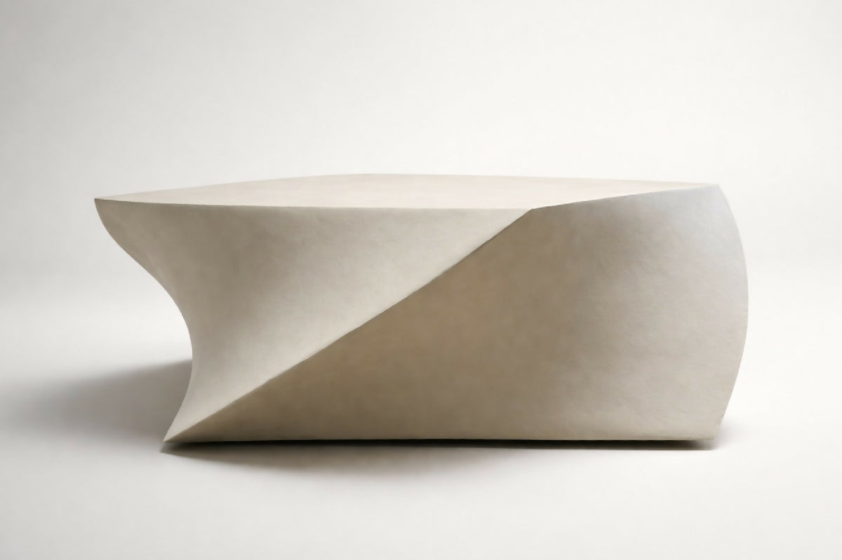 Table basse blanche au plateau décalé et formes arrondies, vue de côté.