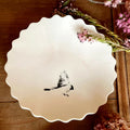 Coupelle en porcelaine blanche à bord festonné, oiseau noir peint à la main