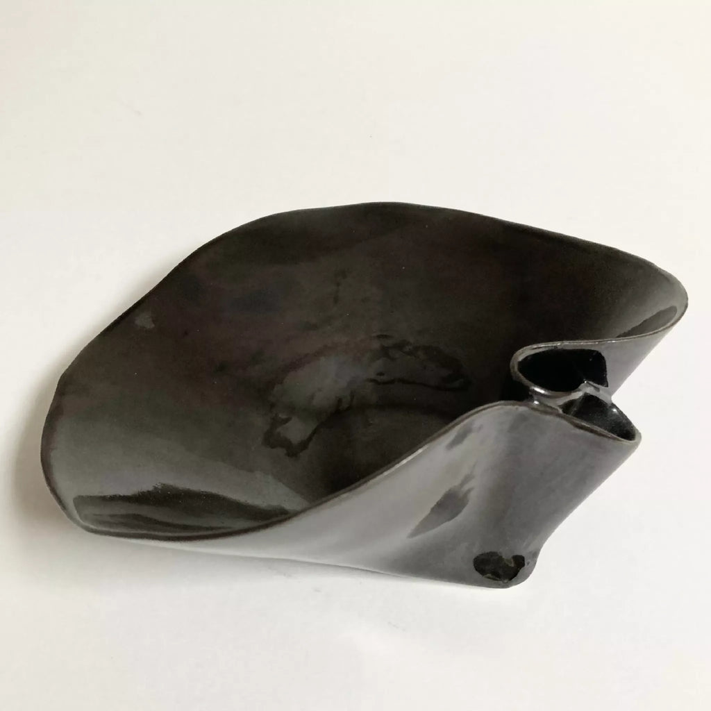 Coupe nénuphar noire en métal brillant, forme nénuphar avec bec et petite anse.