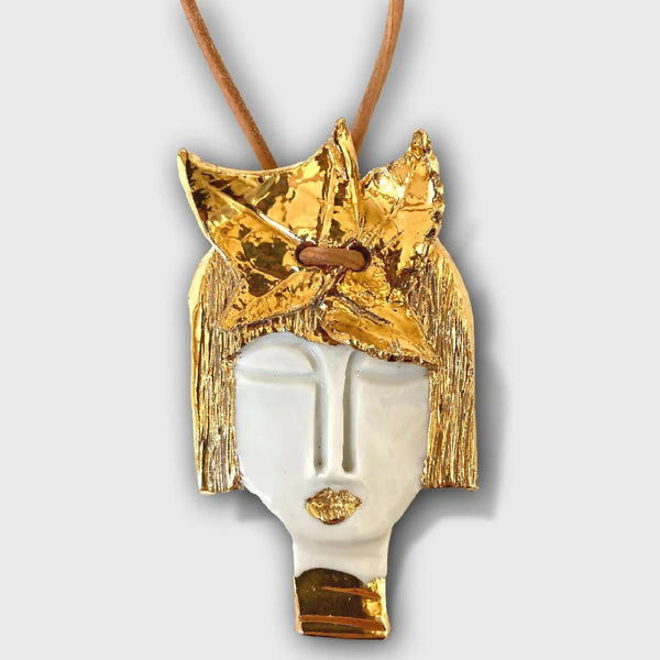 Pendentif visage d’Aphrodite, face dorée et visage blanc, cordon brun