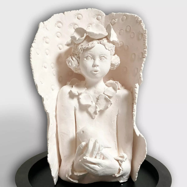 Sculpture femme à l’oiseau en relief, visage et mains tenant un petit oiseau, blanche