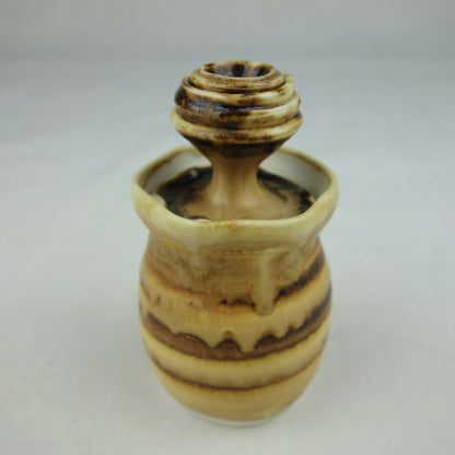 Petit pot en céramique beige et brun, silhouette arrondie, vue en légère perspective