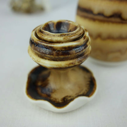 Base et ouverture d’un petit pot en céramique beige et brun, détails des stries