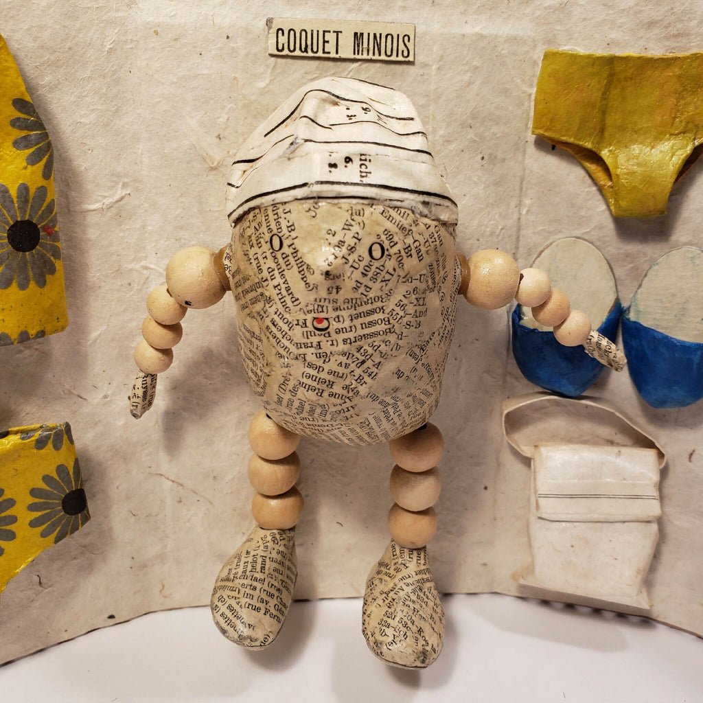 Sculpture Coquet minois : figurine en tissu beige, détails imprimés et accessoires