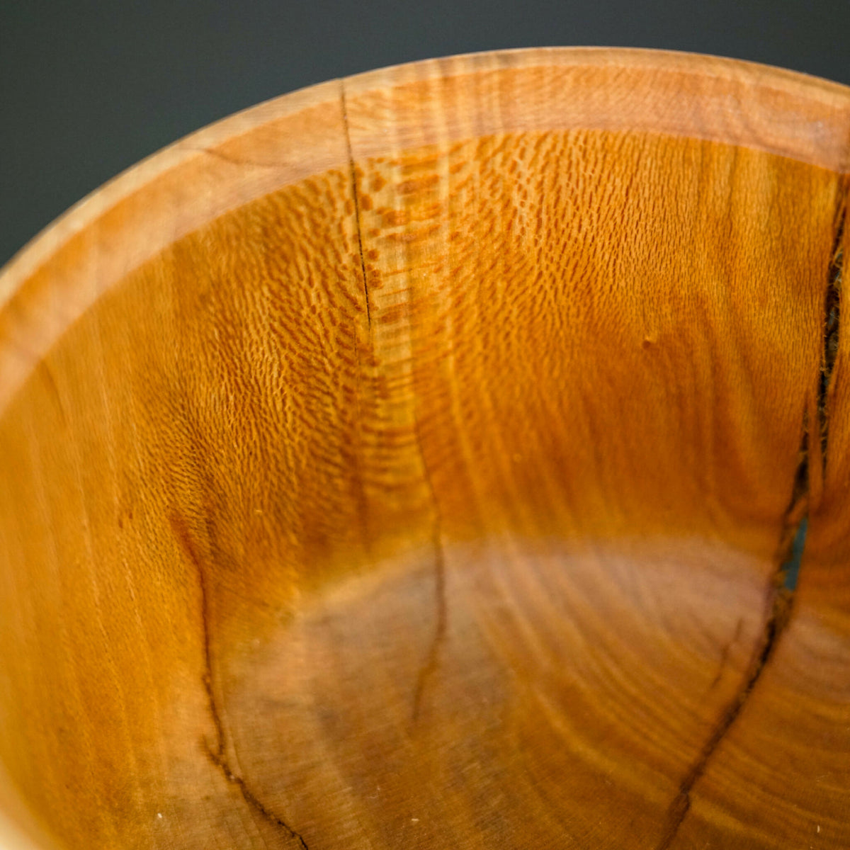 Bol en bois : gros plan sur le grain et l’intérieur arrondi, finition naturelle.