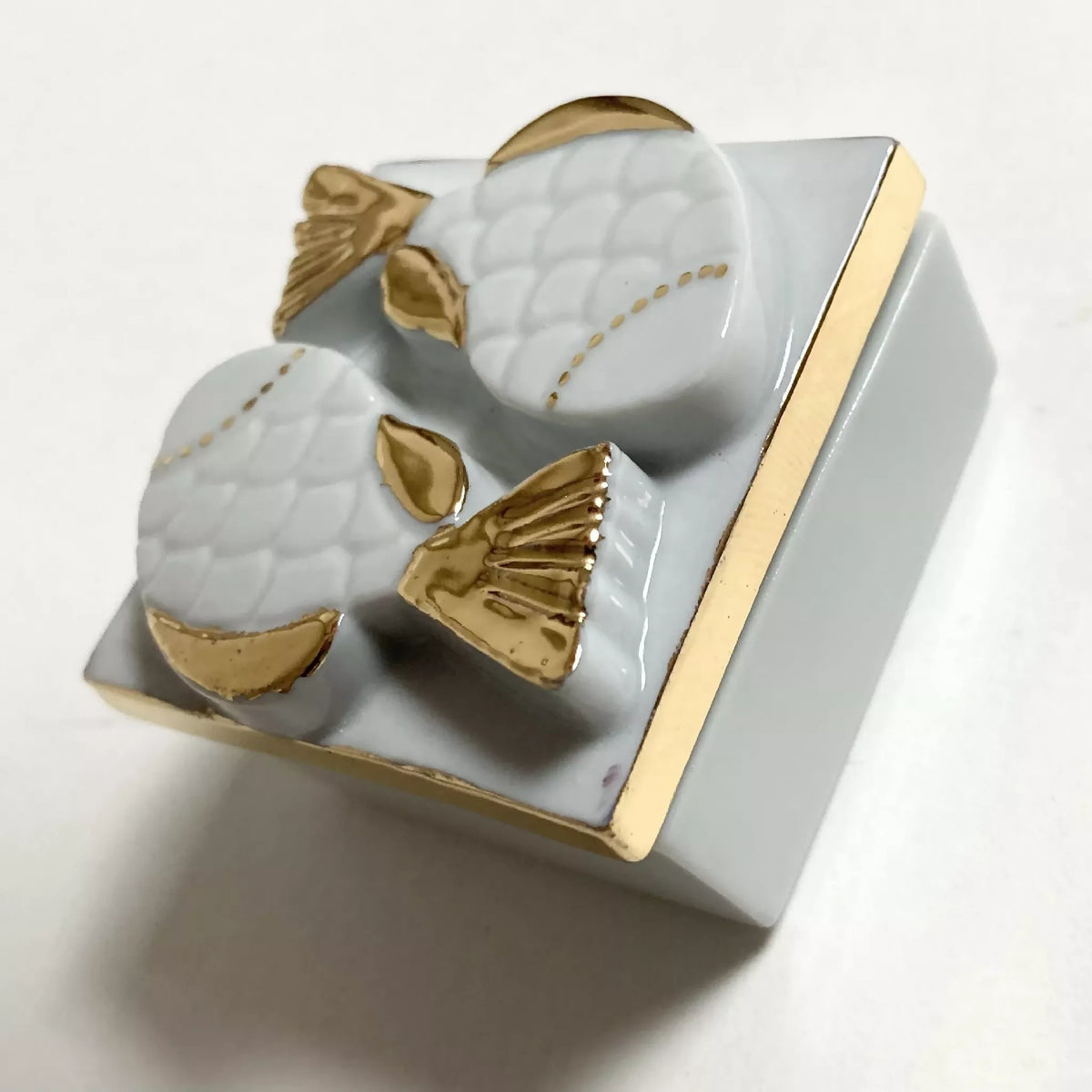 Boîte à bijoux en porcelaine blanche, motif poissons dorés sur le couvercle, angle