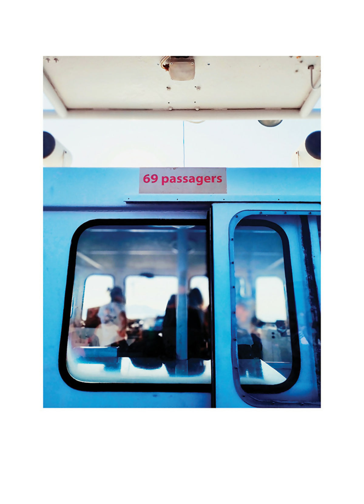 Photo encadrée, gros plan sur bus bleu avec panneau « 69 passagers »