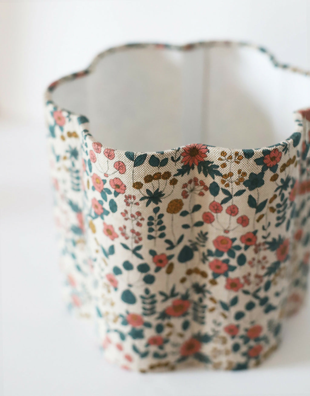 Abat-jour en tissu fleuri beige, vue intérieure sur le tissu et les coutures.