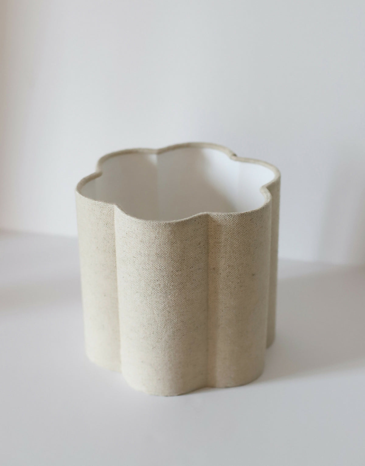 Abat-jour forme fleur en tissu uni beige clair, ouverture intérieure blanche, côtés arrondis