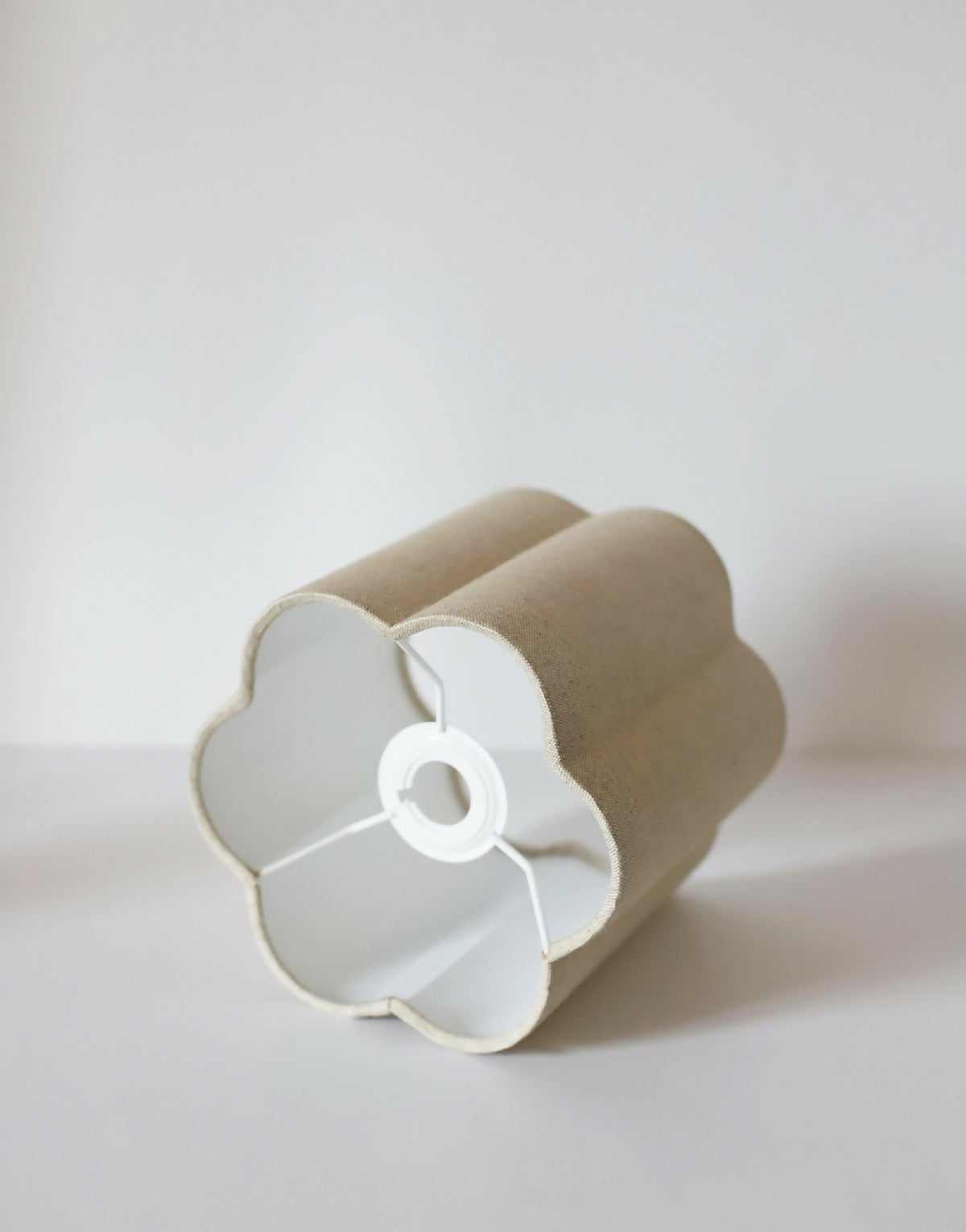 Abat-jour forme fleur tissu beige, dessous avec support central blanc et câble