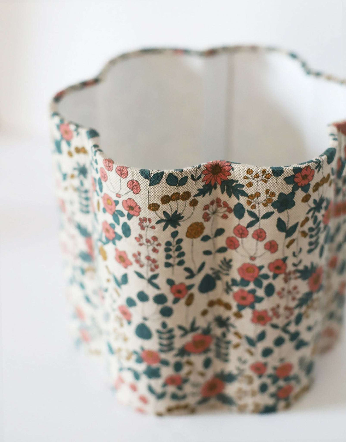 Abat-jour en tissu fleuri beige, vue intérieure sur le tissu et les coutures.