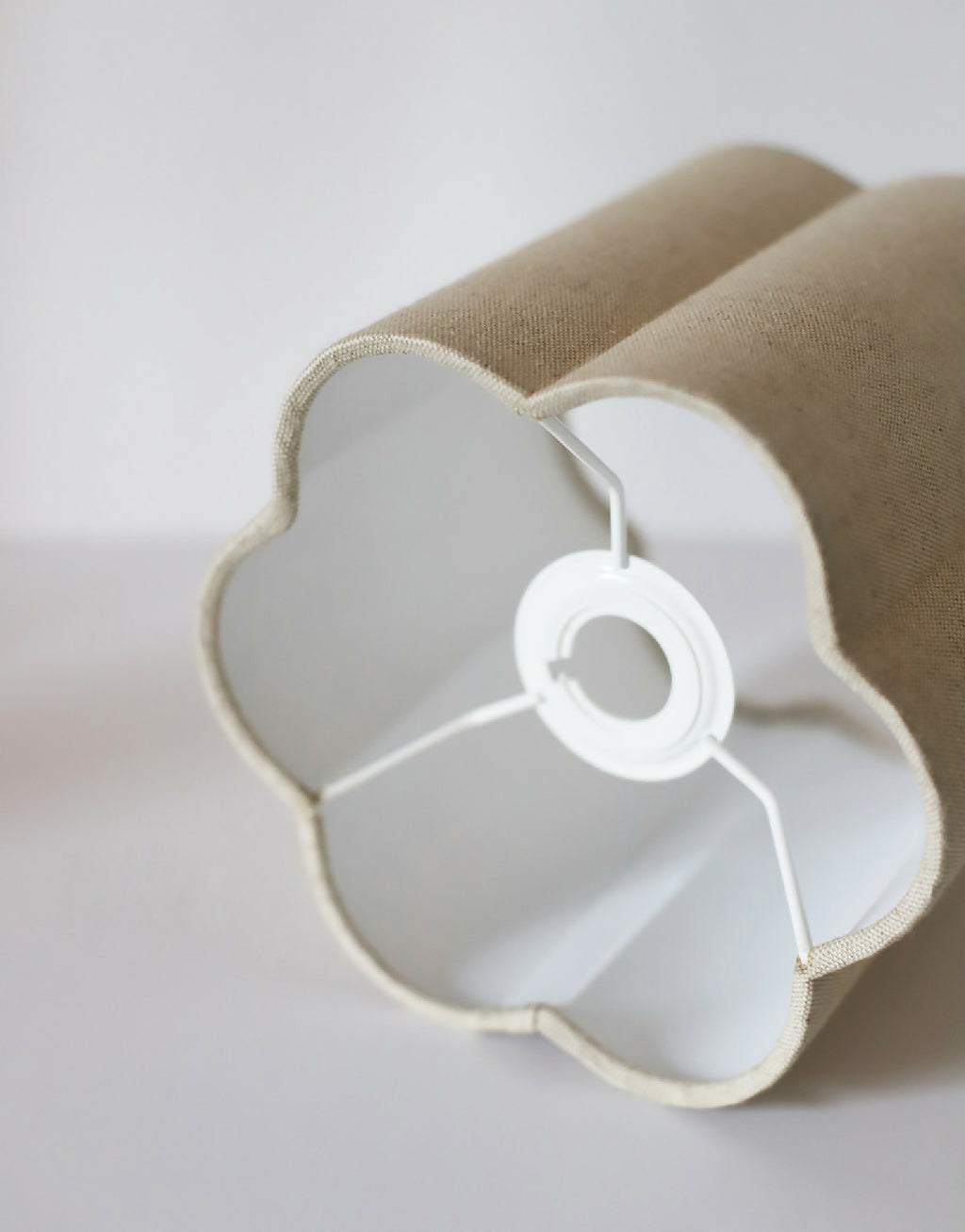 Abat-jour forme fleur tissu beige, vue rapprochée du support central et du câble blanc