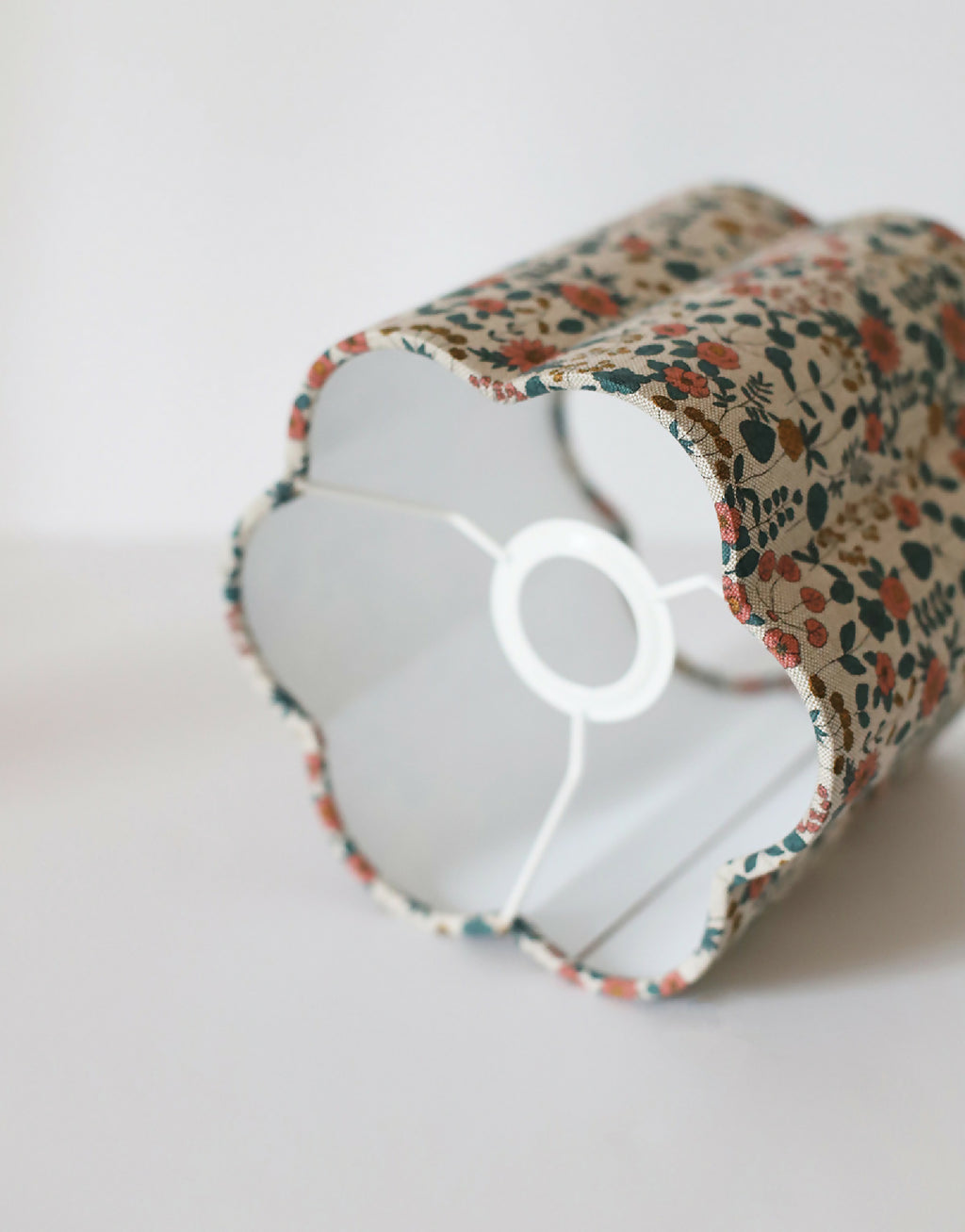 Abat-jour fleuri beige, vue rapprochée de l’intérieur blanc et de la structure.