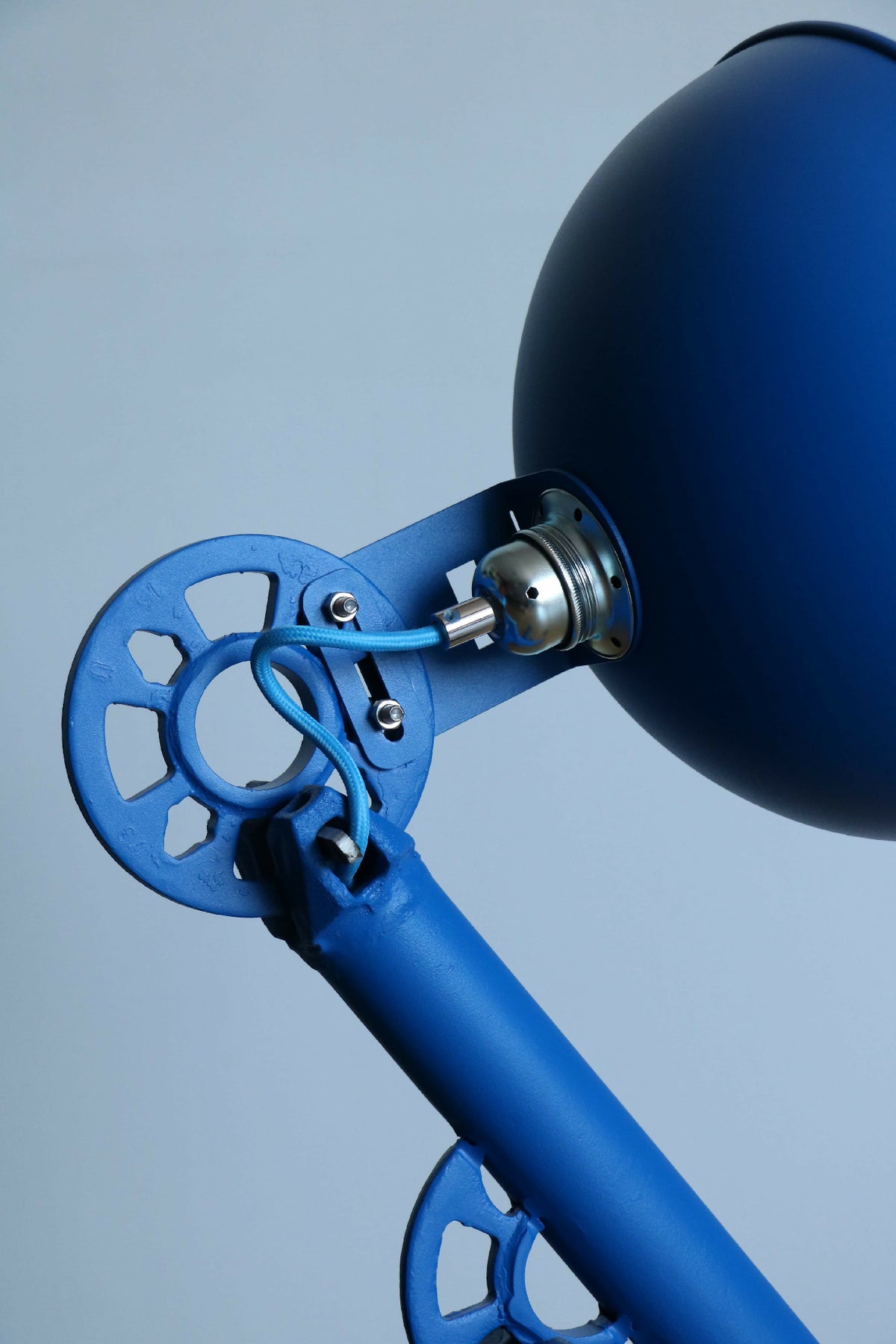 Lampe bleue : bras et douille métallique près de l’abat-jour