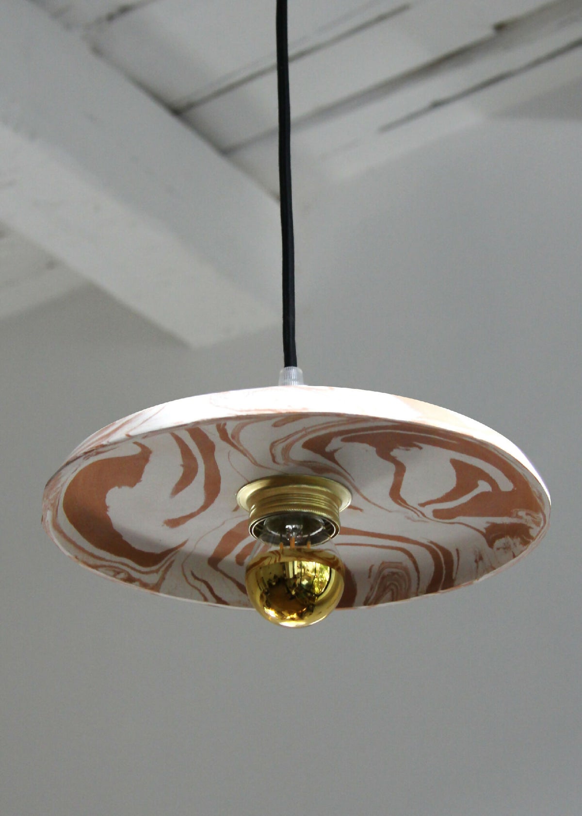 Suspension ronde marbrée beige et marron, câble noir, rosace dorée visible