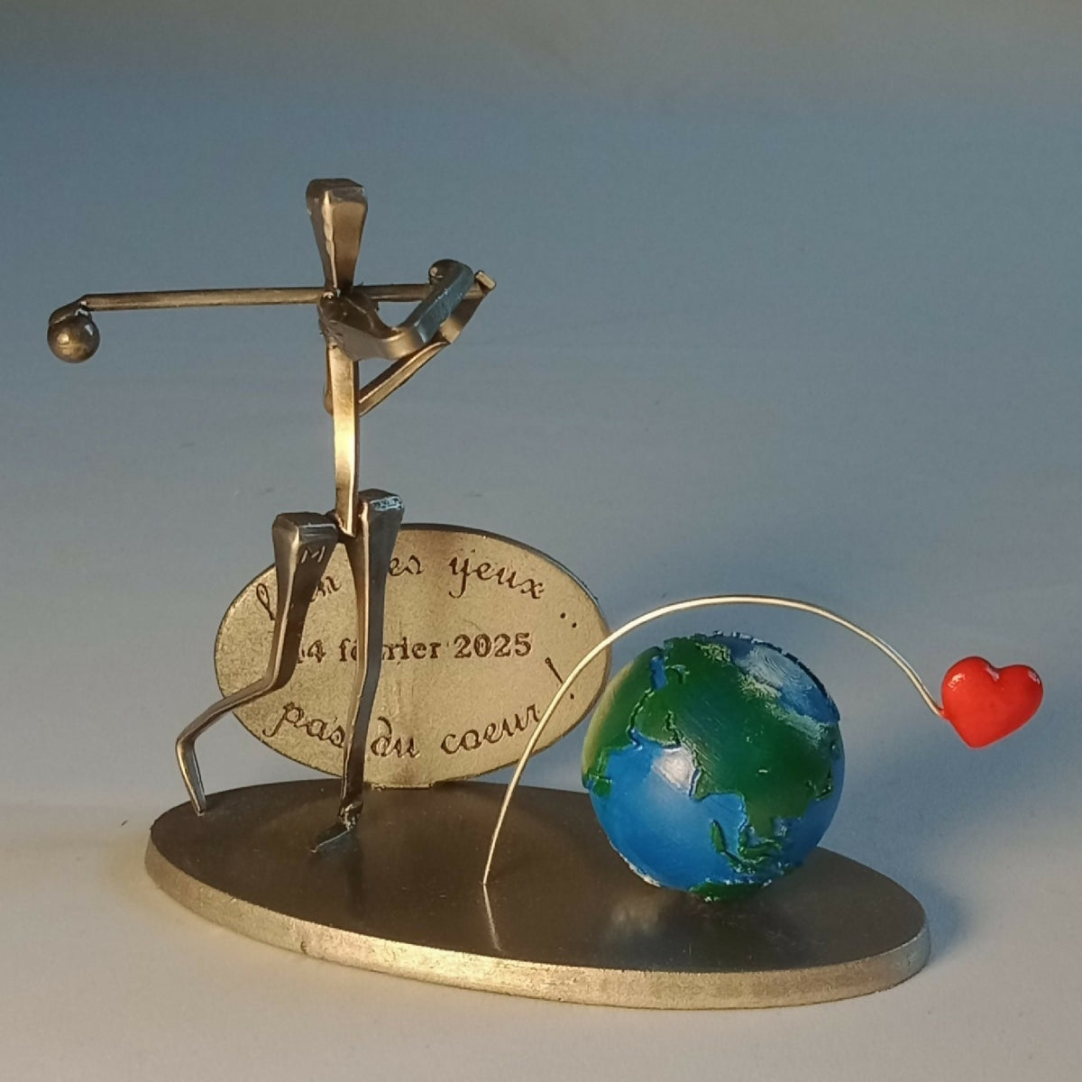 Statuette de golfeur en métal doré, globe bleu-vert et cœur rouge, sur socle