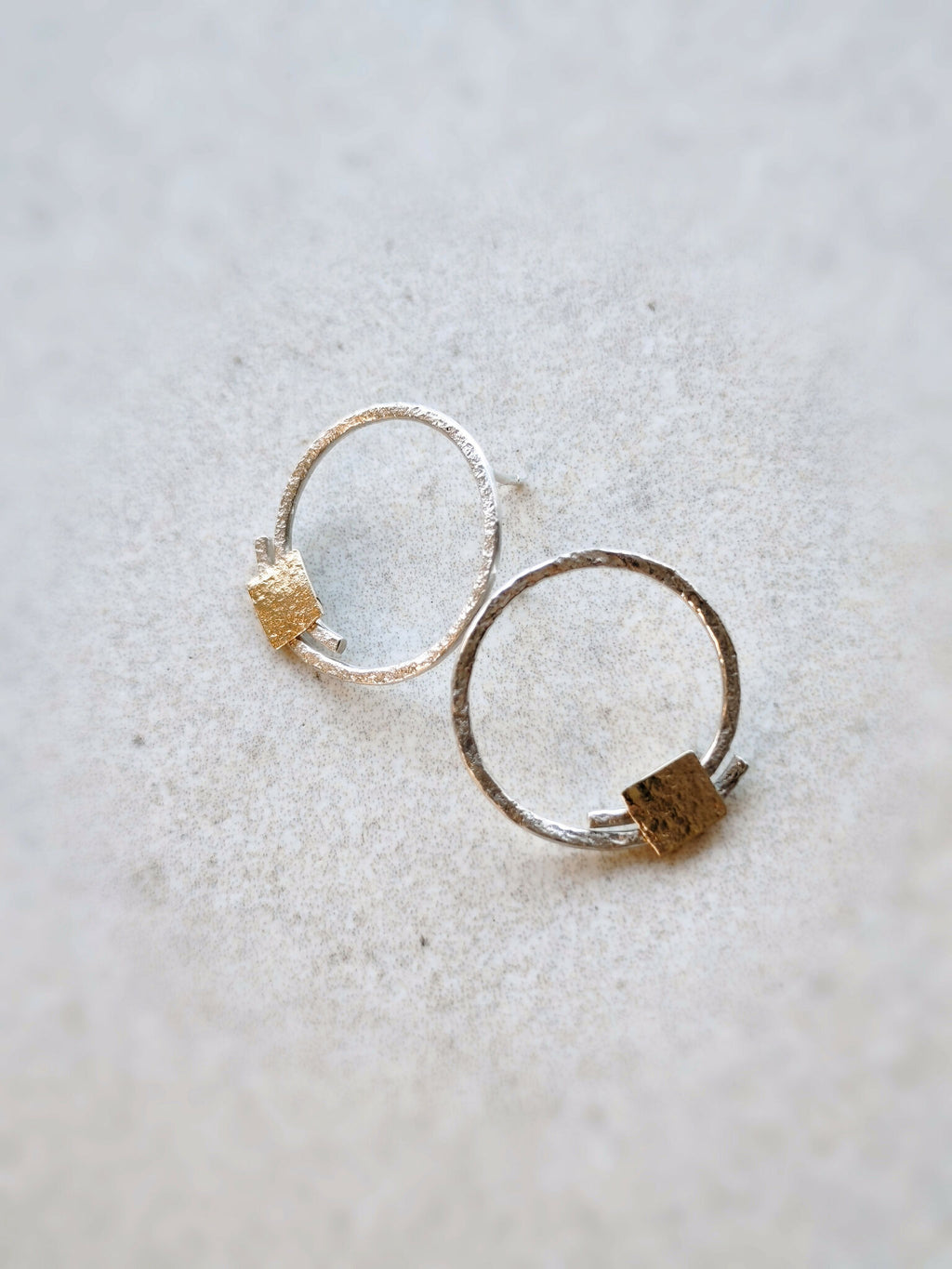 Paire de boucles d’oreilles créoles argentées et pastilles carrées dorées, vue de côté