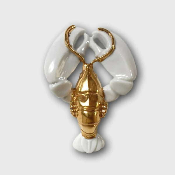 Porte-couvert homard blanc et doré, forme de pinces et queue décoratives.