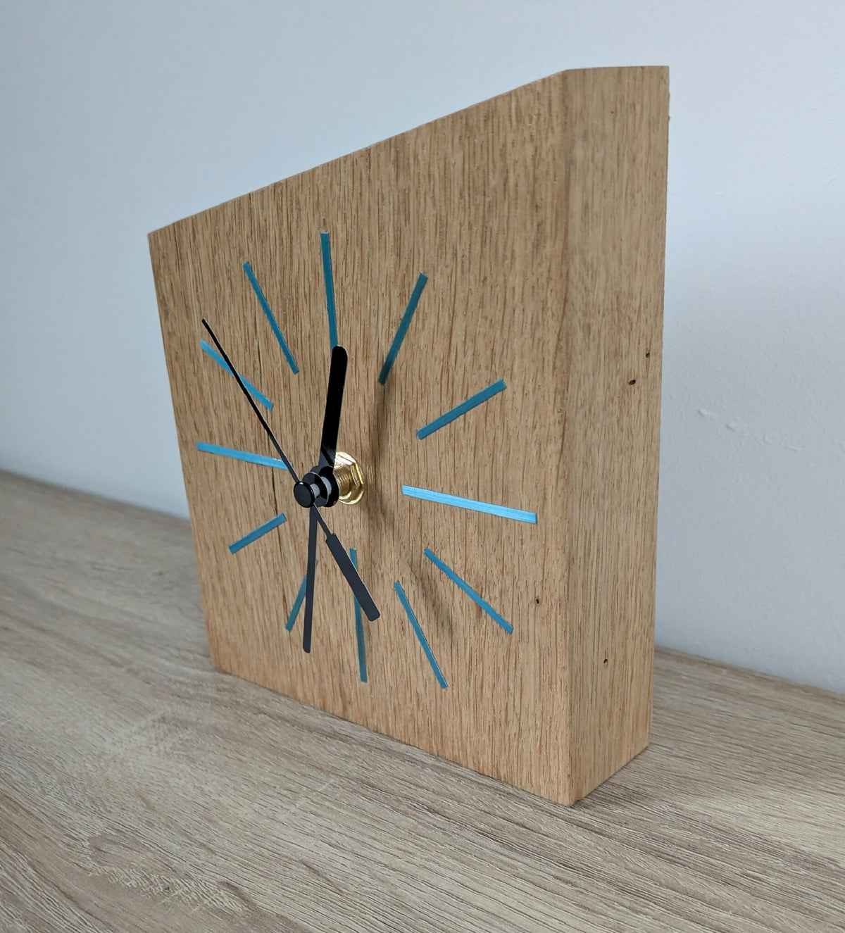 Horloge de bureau en bois avec repères bleus, aiguilles noires et bouton doré