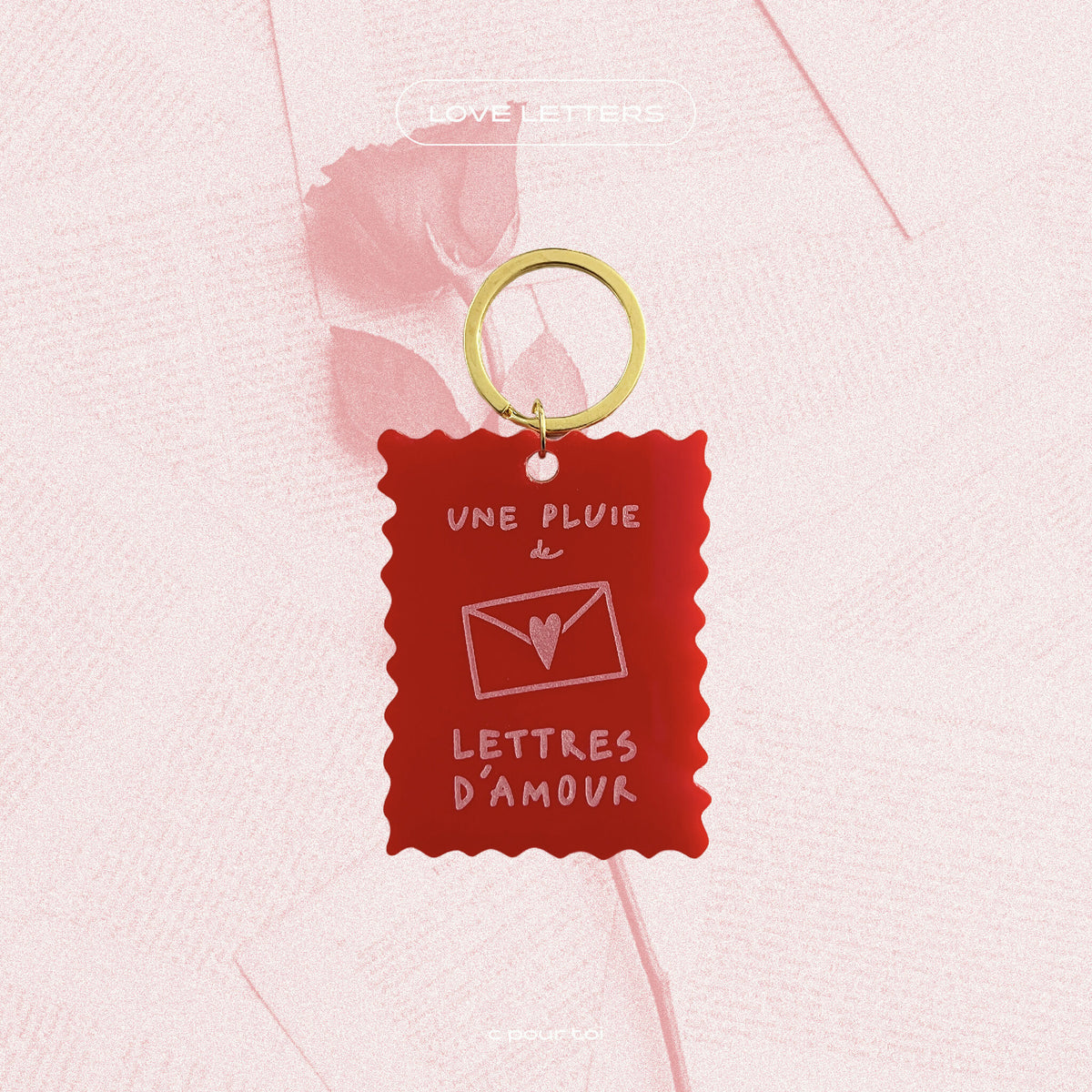 Porte-clés rouge « Une pluie de lettres d’amour » sur anneau doré.