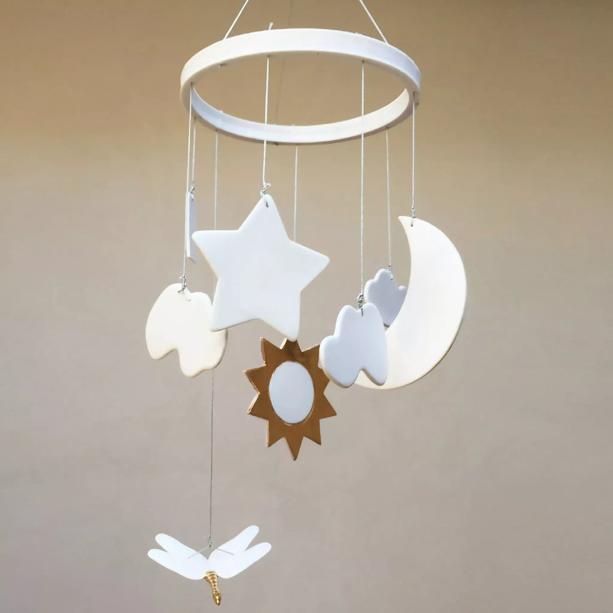 Mobile de naissance : étoile blanche, lune blanche et nuage bleu suspendus.