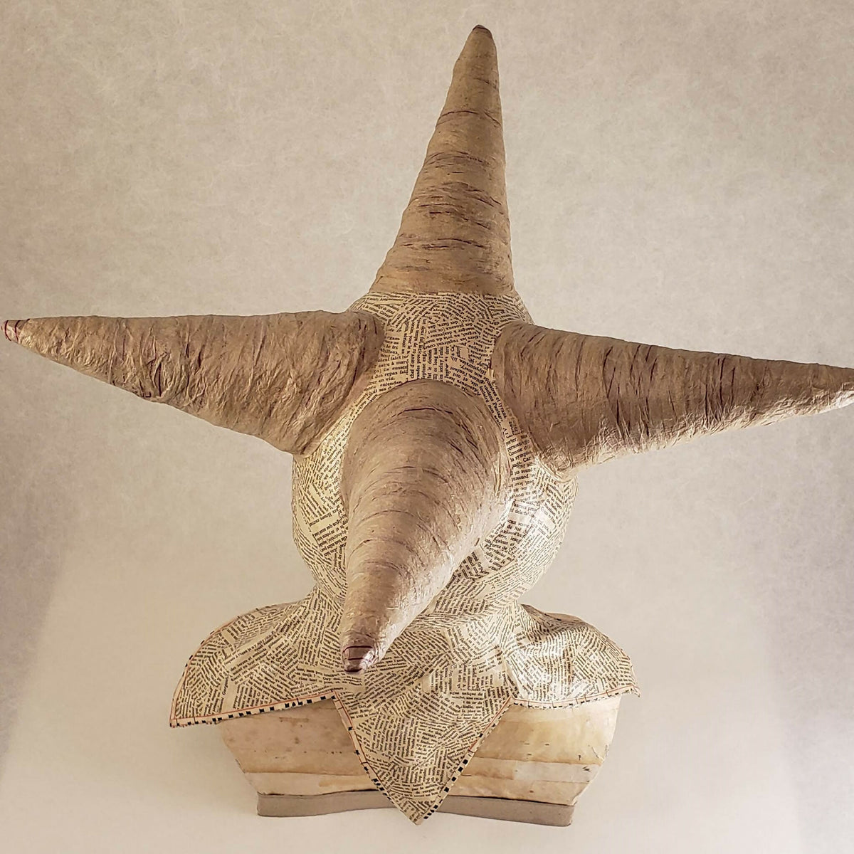 Buste sculpté beige à cornes, vue arrière en légère plongée, papier texturé et base en carton