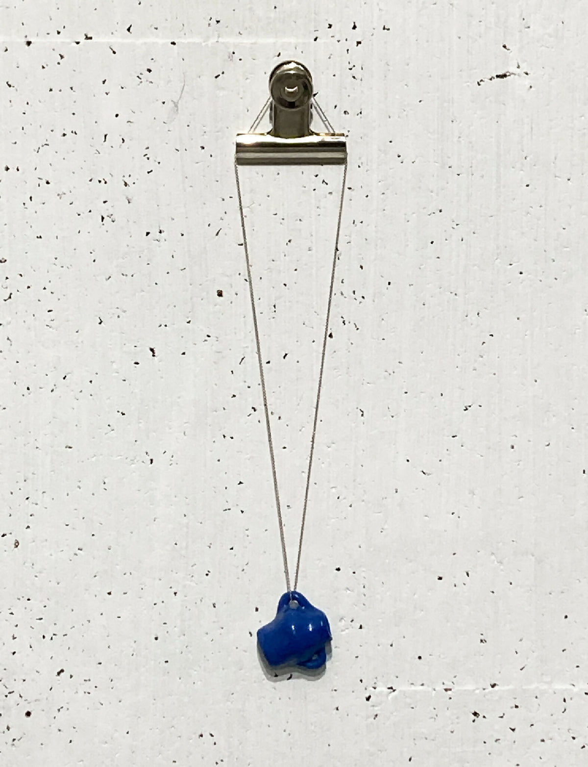 Pendentif en porcelaine bleue sur chaîne en argent avec fermoir métallique.