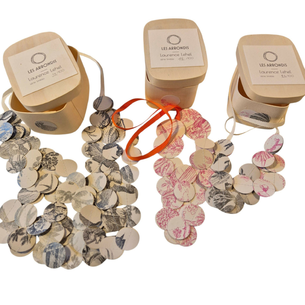 Colliers en disques ronds à motifs, assortis beige, noir et roses, présentés sur fond blanc